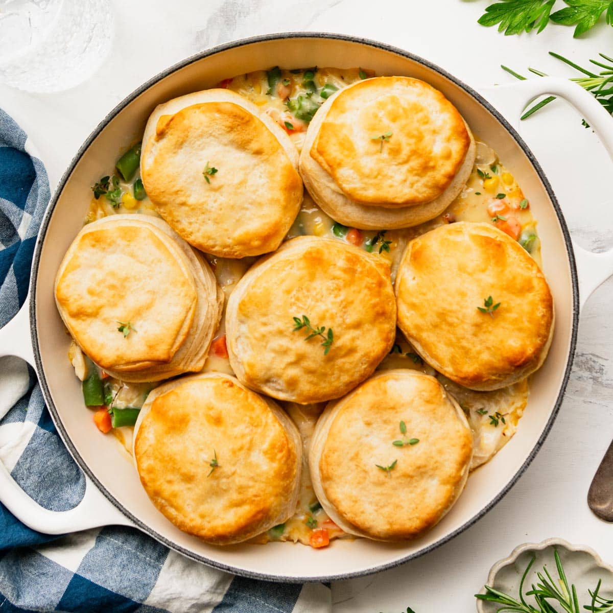 White cast iron pan full of chicken pot pie with biscuits.