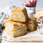 Horizontal side shot of flaky biscuits on a white wooden board.