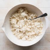 Mixing biscuit dough in a white bowl.