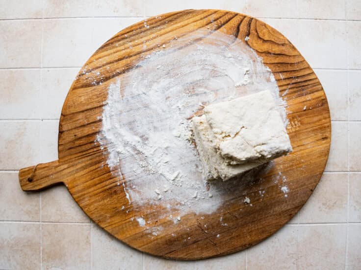 Stacking layers of biscuit dough to create flaky layers.