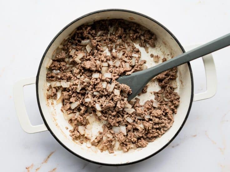 Browning ground beef, onion, and garlic in a skillet.