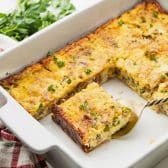 Square side shot of an overnight breakfast casserole with bacon, eggs, sausage, and cheese.