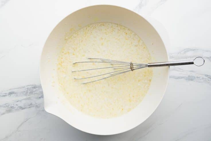 Whisking together Bisquick, eggs, and milk for an overnight breakfast casserole.