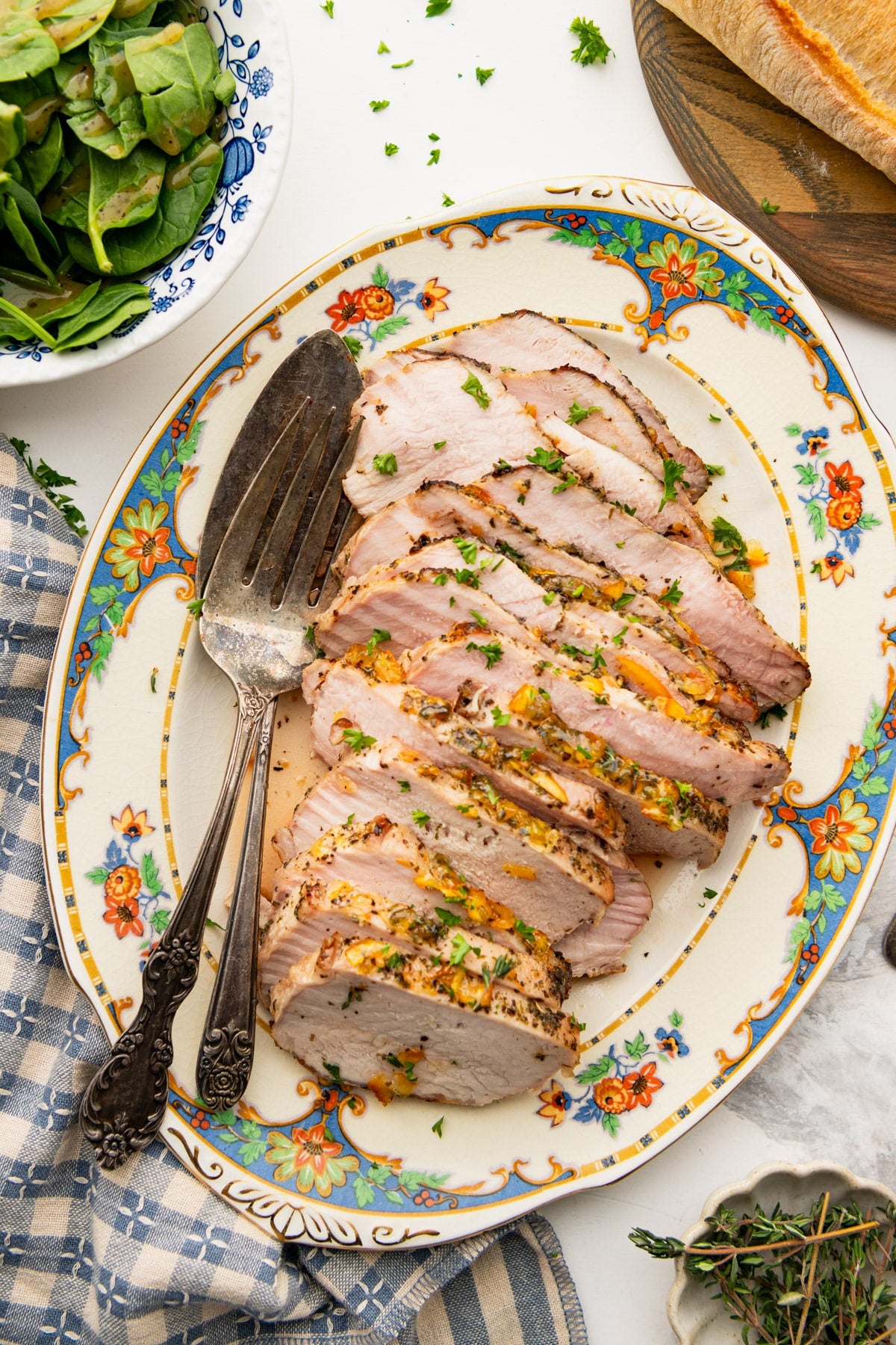 Overhead shot of a sliced pork sirloin roast on an antique serving tray.