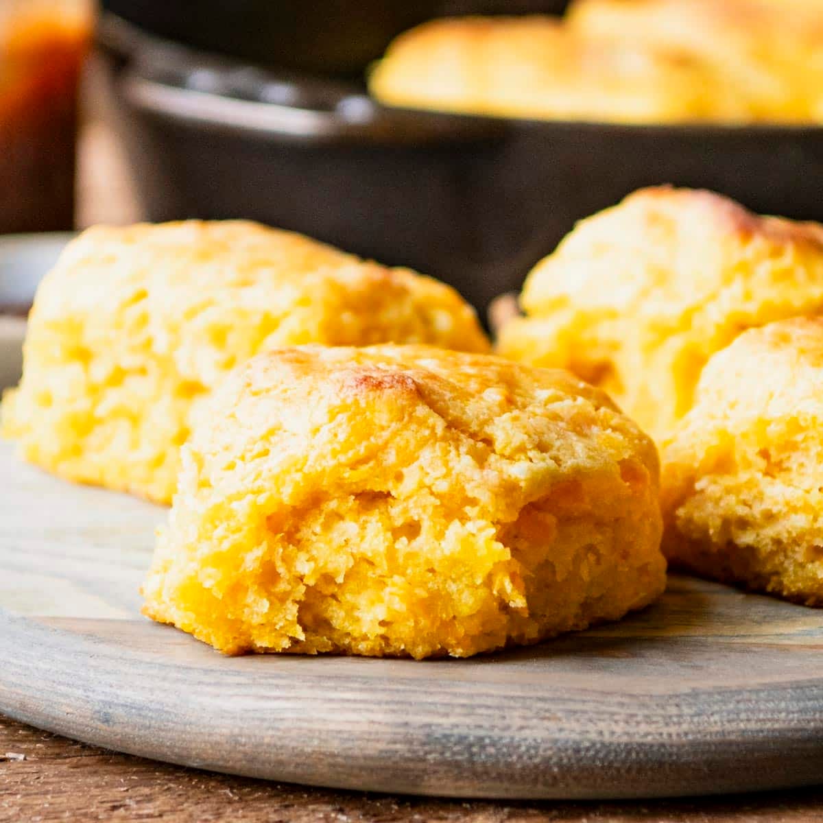 Square side shot of old fashioned sweet potato biscuits on a wooden serving board.