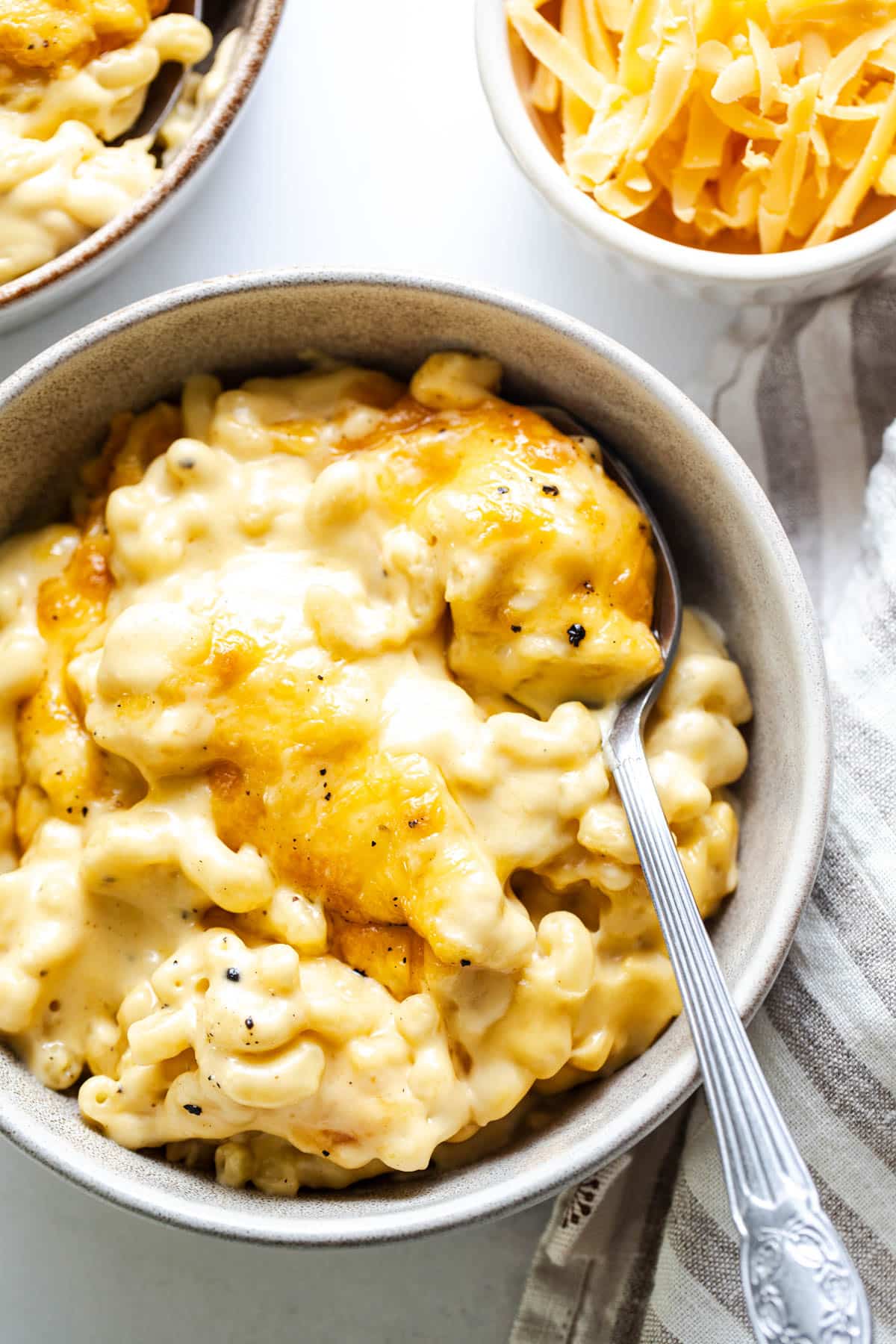 Overhead shot of creamy baked mac and cheese in white serving bowls.
