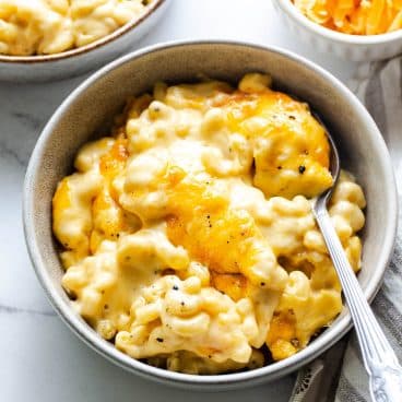 Square overhead shot of a bowl of creamy baked mac and cheese.