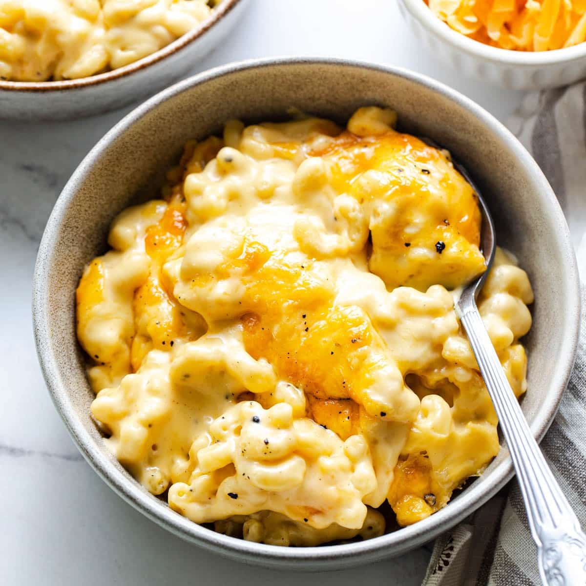 Square overhead shot of a bowl of creamy baked mac and cheese.