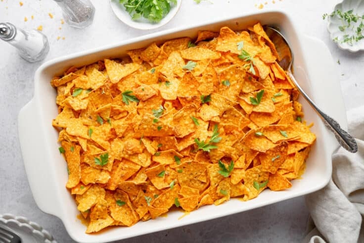 Horizontal overhead shot of a baked Dorito chicken casserole in a white dish.
