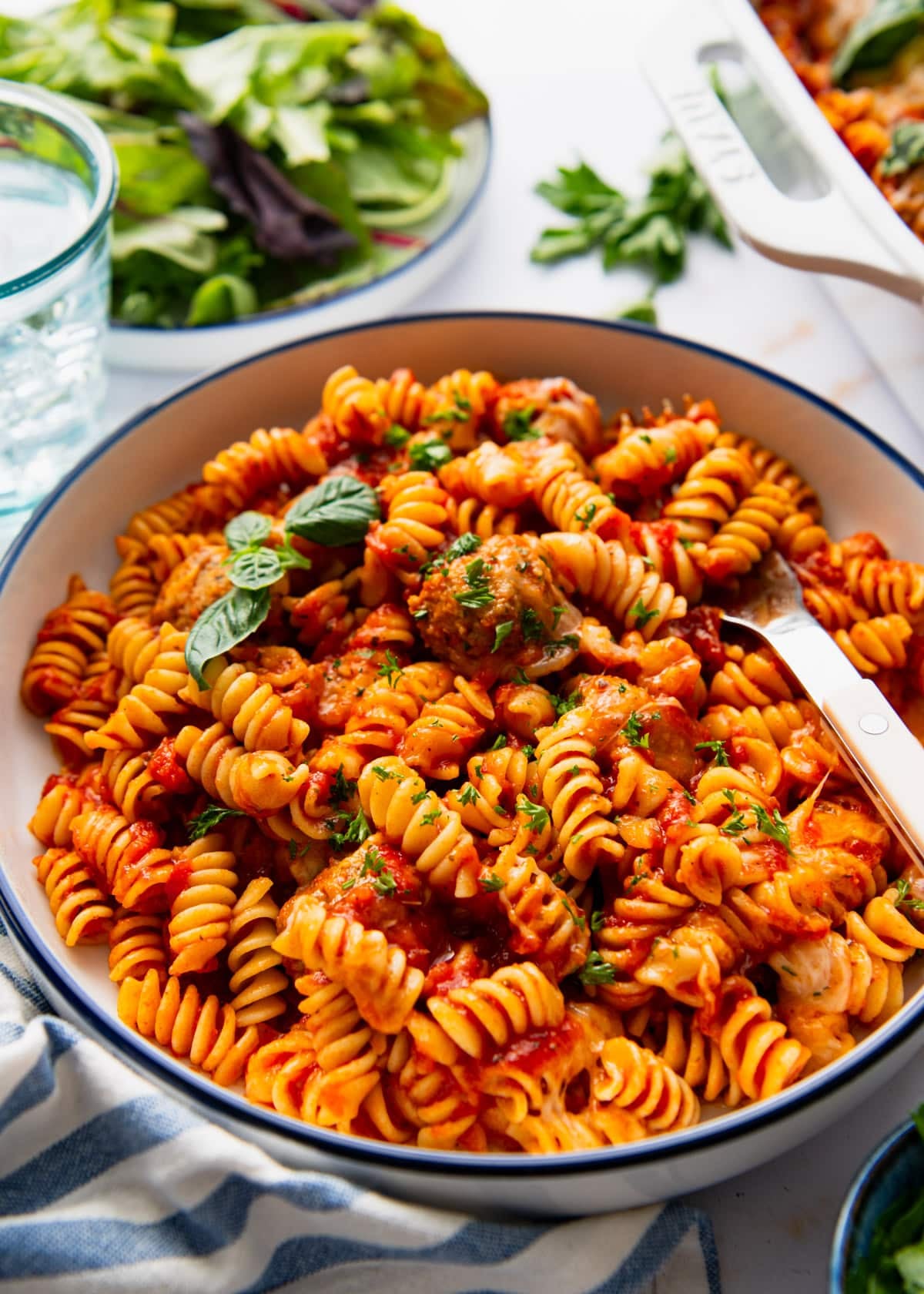 Side shot of a fork in a bowl of dump and bake meatball casserole.