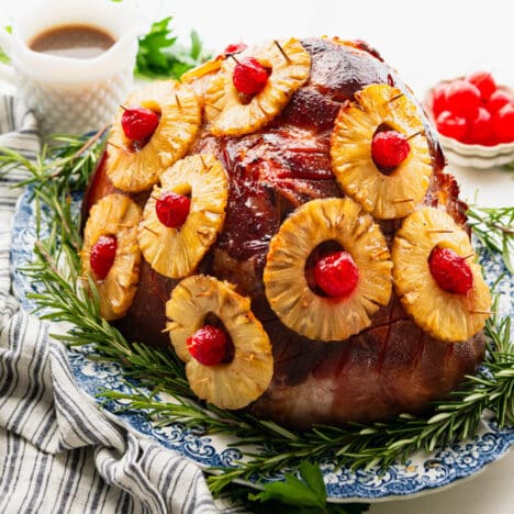 Square side shot of a pineapple glazed ham on a platter.