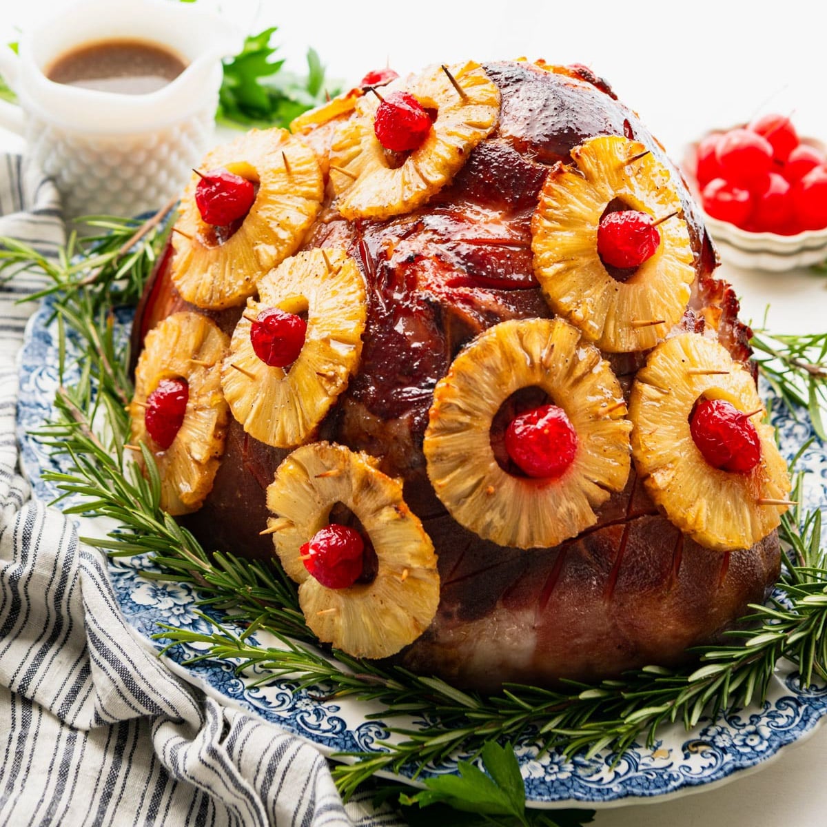 Square side shot of a pineapple glazed ham on a platter.