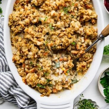 Square overhead shot of a leftover turkey and stuffing casserole in a white baking dish.