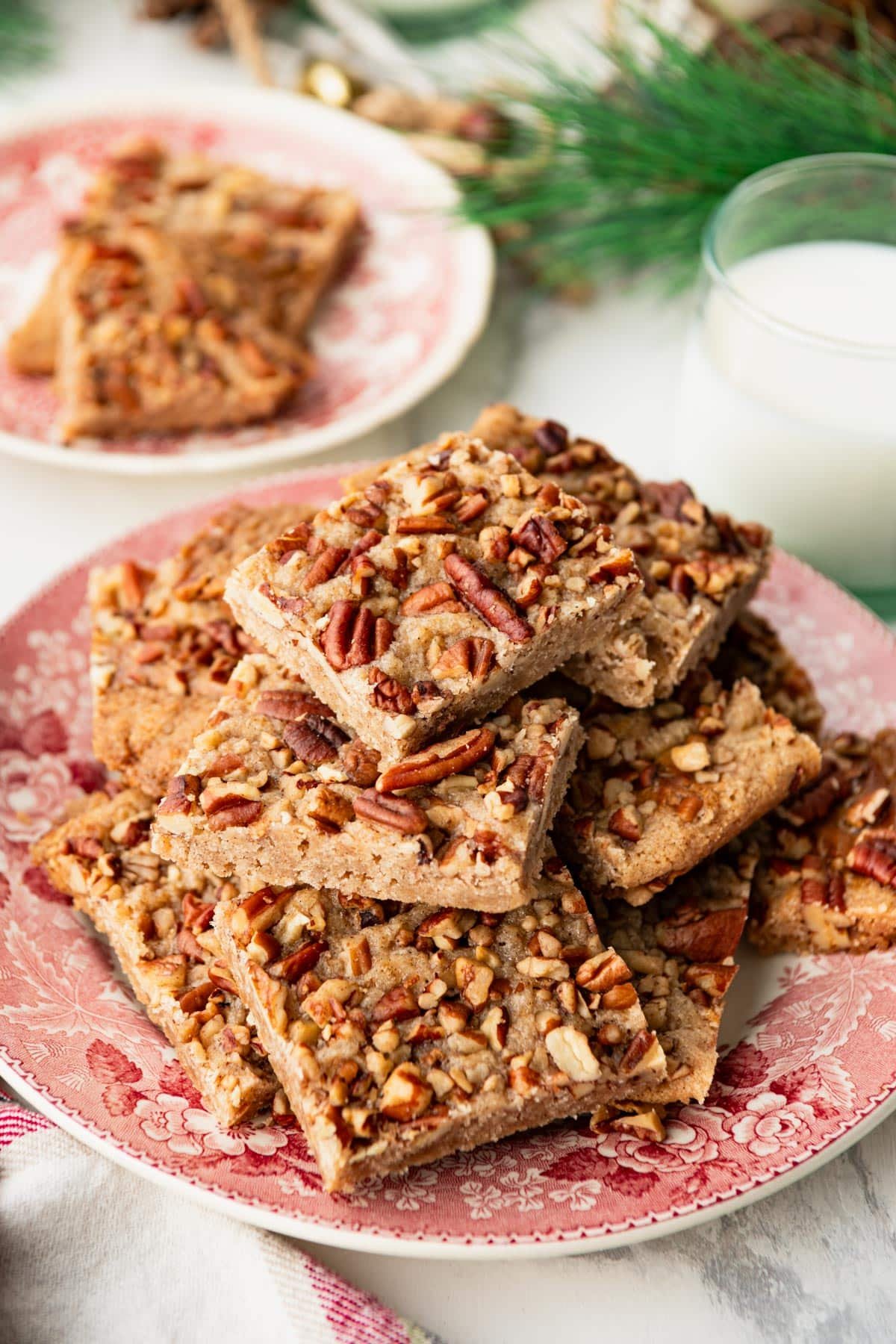 Side shot of a vintage red and white plate full of old fashioned pecan bars.