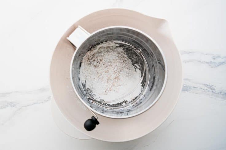 Sifting the dry ingredients for pecan bars.