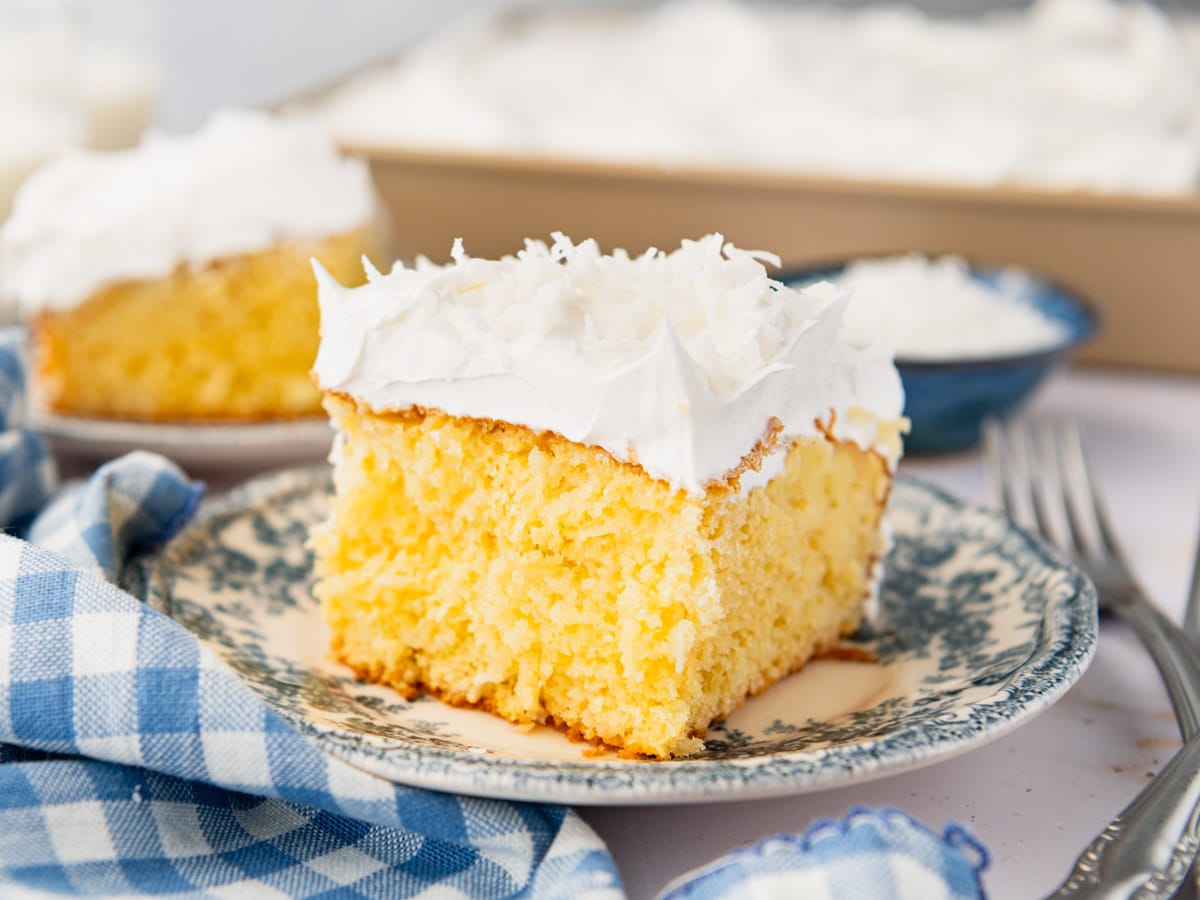 Close up side shot of a slice of coconut cream poke cake on a plate.