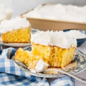 Horizontal side shot of two slices of coconut cream cake on small blue plates.