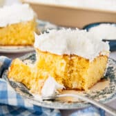 Square side shot of a slice of coconut cream poke cake on a plate.