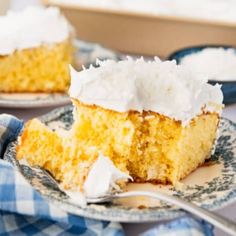 Square side shot of a slice of coconut cream poke cake on a plate.