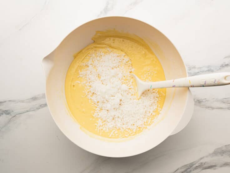 Folding the coconut into the cake batter.