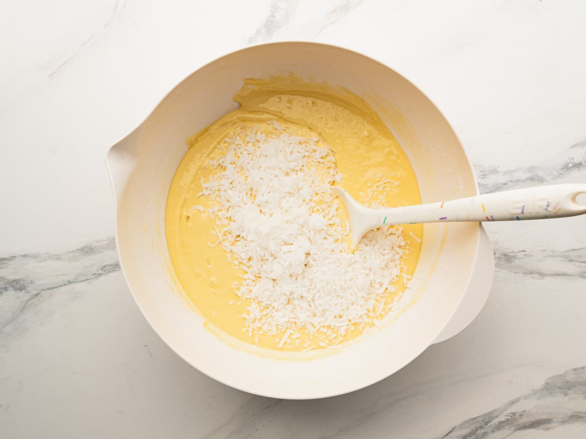 Folding the coconut into the cake batter.
