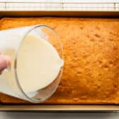 Pouring the soaking mixture over the cake.