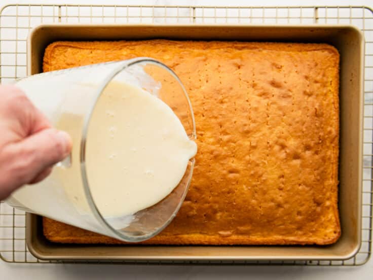 Pouring the soaking mixture over the cake.