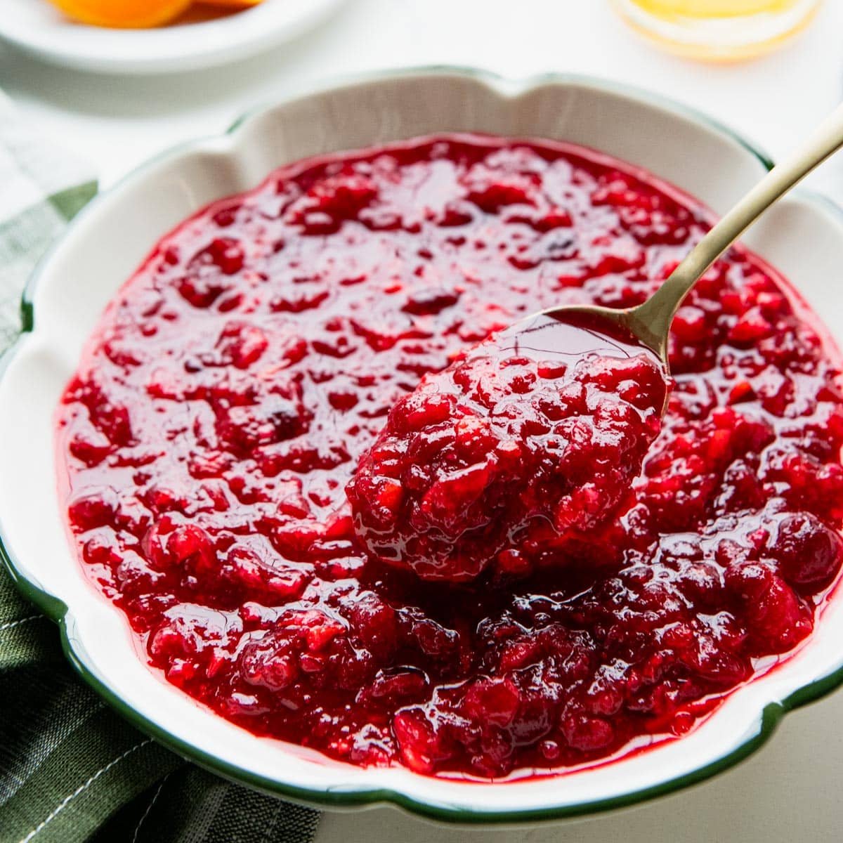 Square side shot of a spoon serving cranberry orange relish.