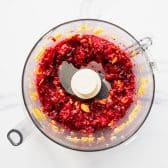 Pulsing cranberries and oranges for relish in a food processor.
