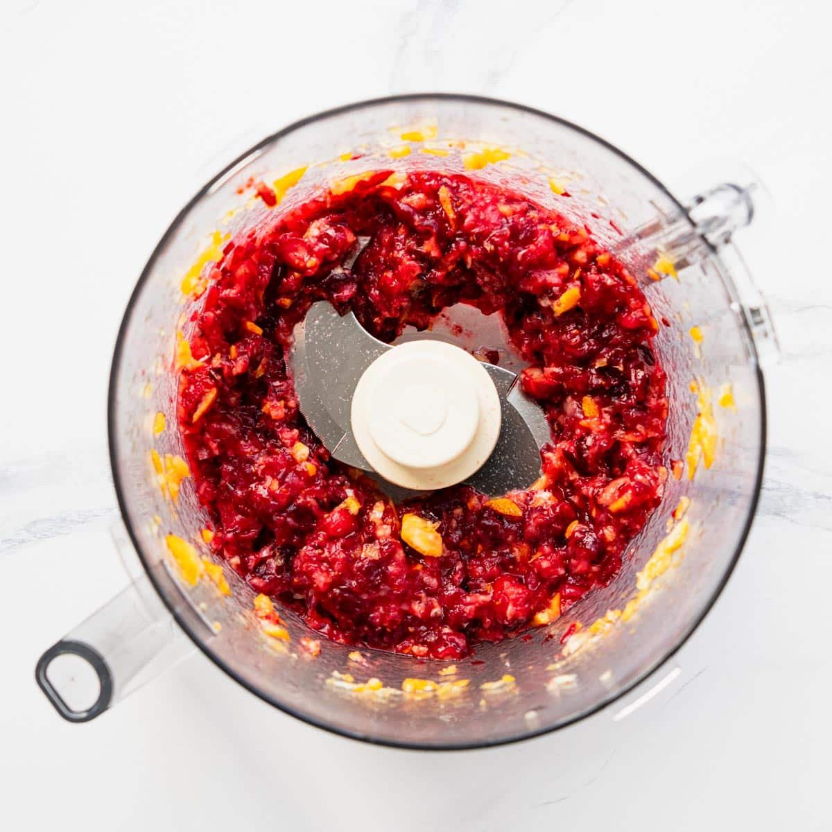 Pulsing cranberries and oranges for relish in a food processor.