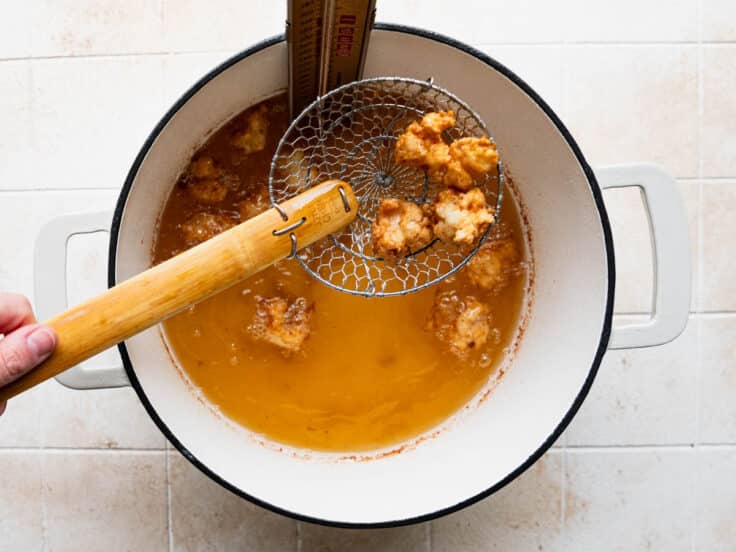 Frying shrimp in a Dutch oven full of hot oil.