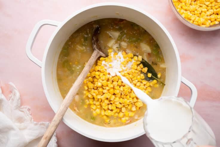 Adding the cream to a pot of shrimp soup.
