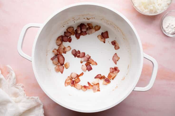 Cooking chopped bacon in a pot.