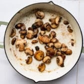 Sauteing mushrooms in the skillet.