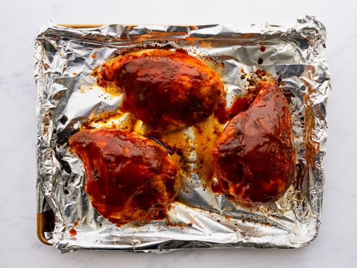 Chicken breast on the pan after brushing with bbq sauce and broiling.
