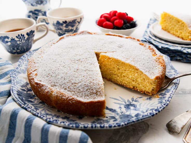 Horizontal side shot of a sliced breakfast cake on a blue and white plate.