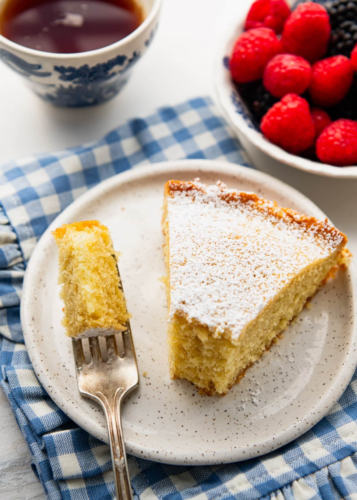 Front shot of a slice of breakfast cake on a white plate on a breakfast table.