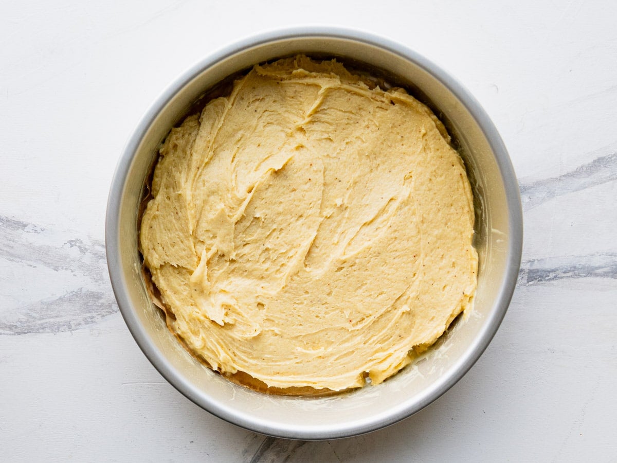 Breakfast cake batter in a round pan before baking.