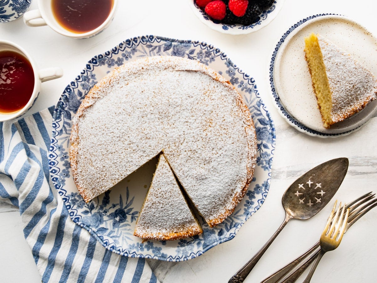 Overhead shot of a sliced breakfast cake on a blue and white plate.
