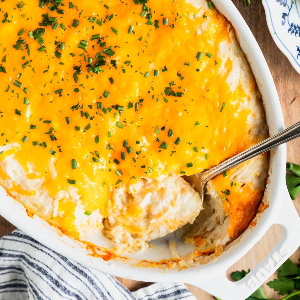 Square overhead shot of a white dish full of an easy cheesy potato casserole.