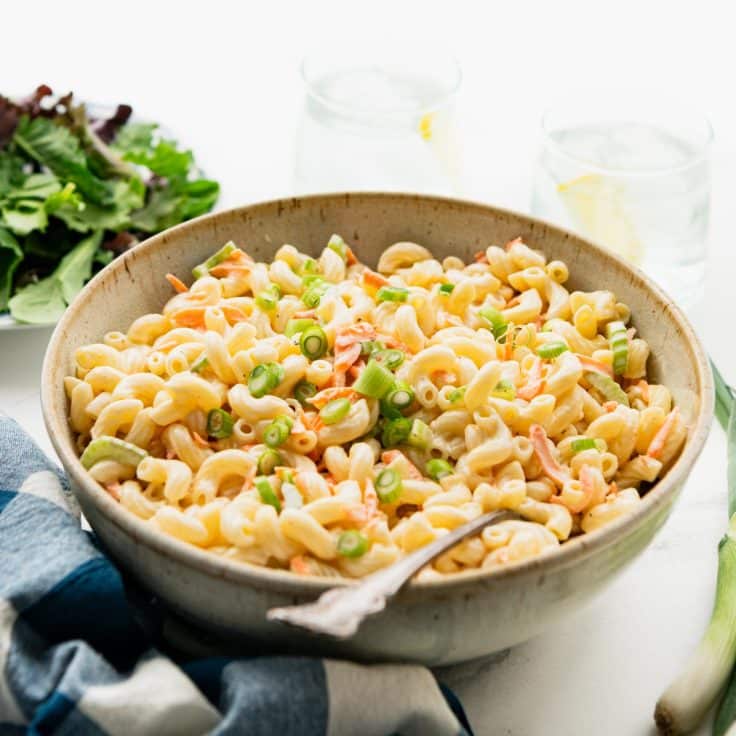 Square side shot of a bowl of hawaiian pasta salad on a table.