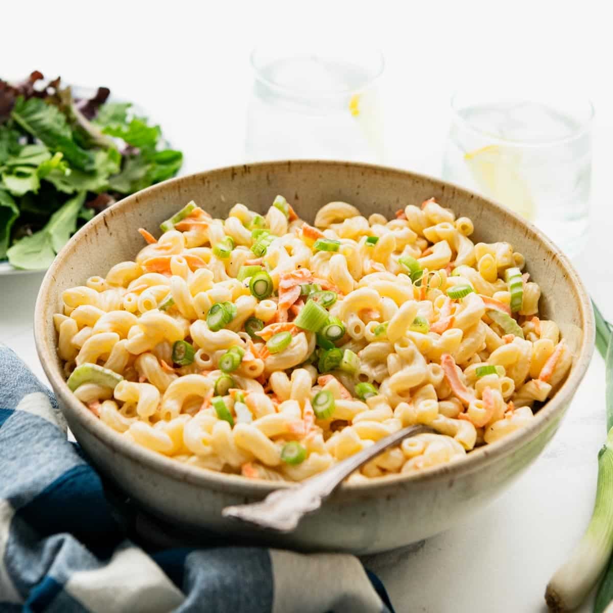 Square side shot of a bowl of hawaiian pasta salad on a table.