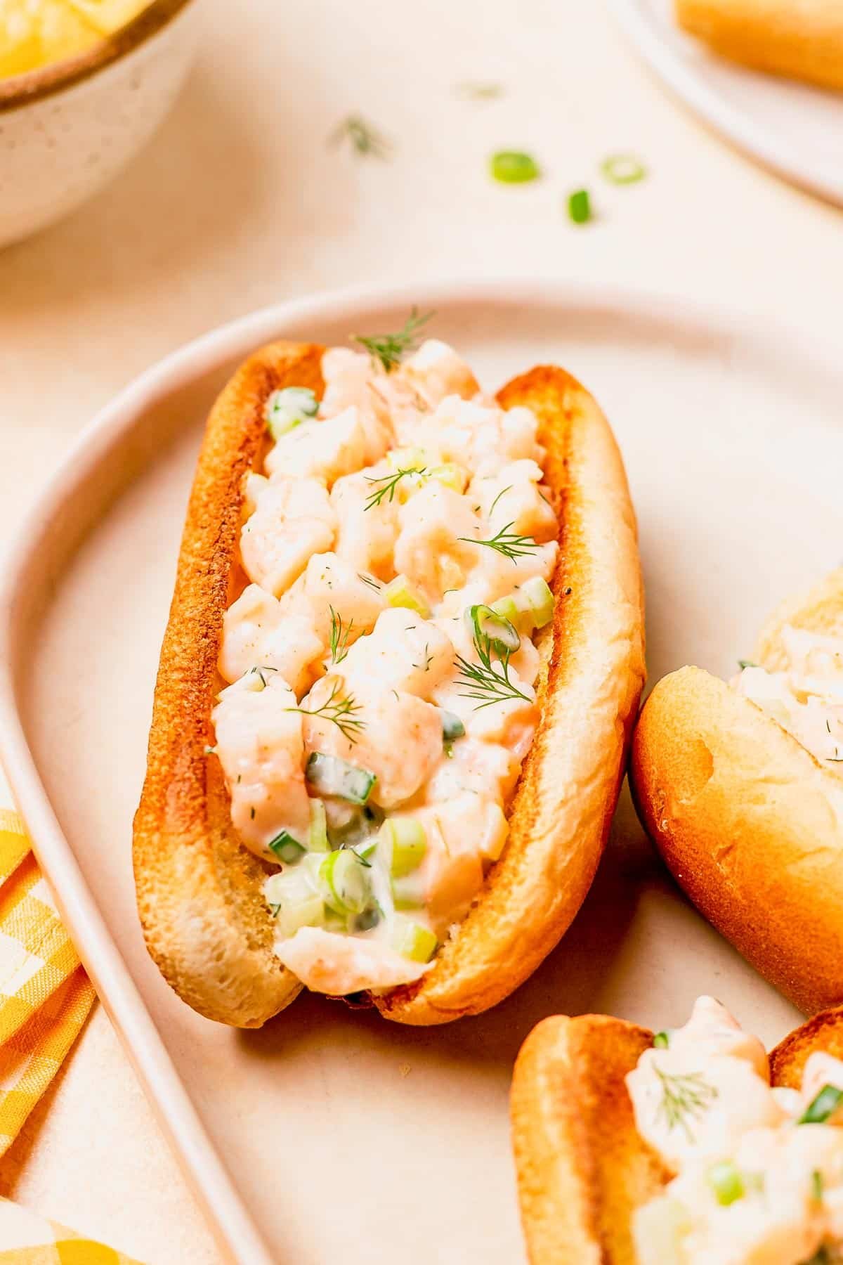 Side shot of a tray of shrimp rolls on a white table.