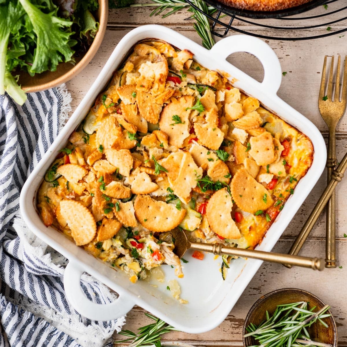 Square overhead image of a chicken and squash casserole in a white dish.