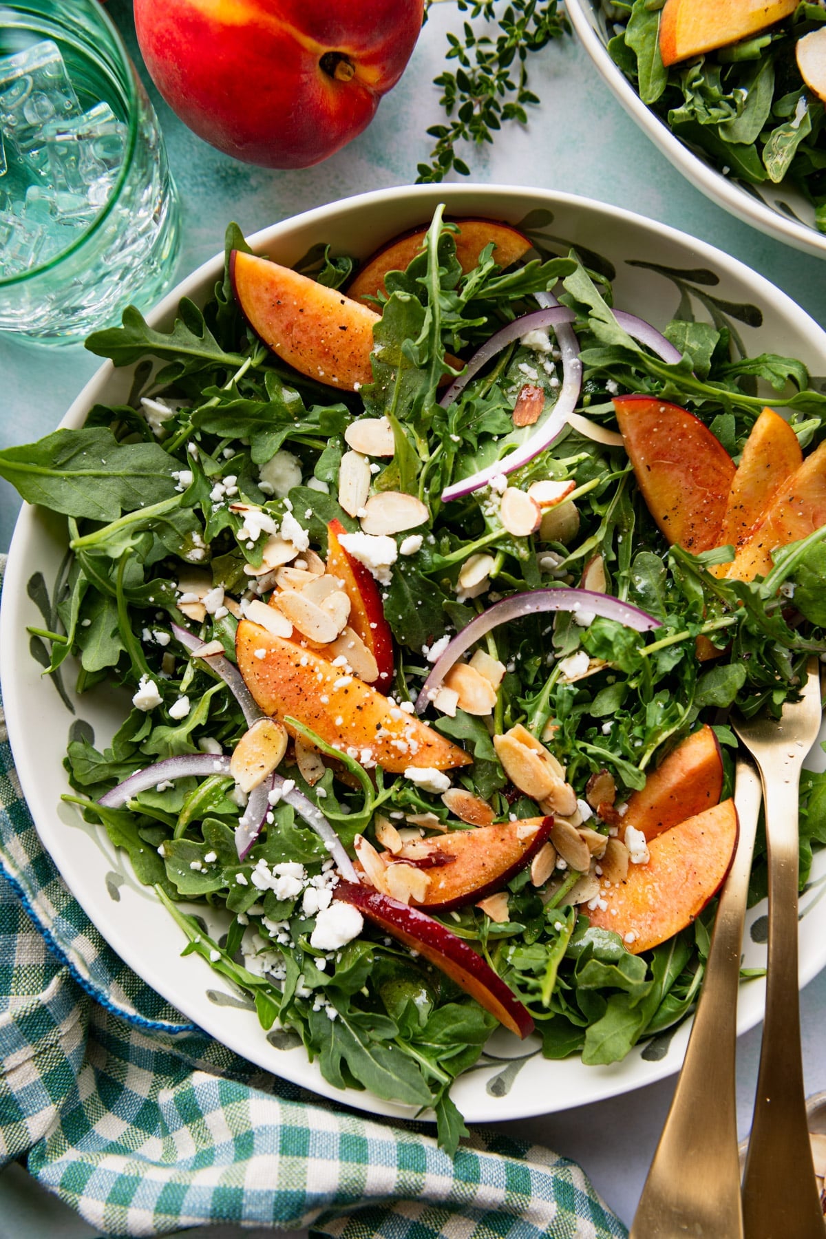 Close overhead shot of a peach salad on a green table with homemade vinaigrette.