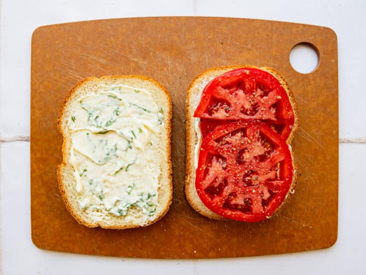 Layering the sliced tomatoes on the bread and mayo.