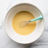 Whisking eggs and broth for cornbread dressing.