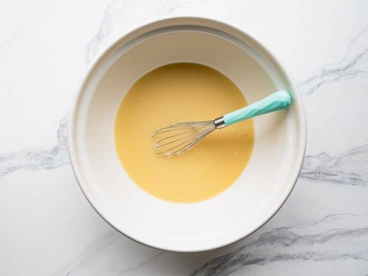 Whisking eggs and broth for cornbread dressing.