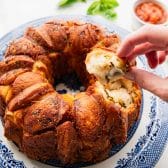 Hand pulling out a piece of garlic bread.