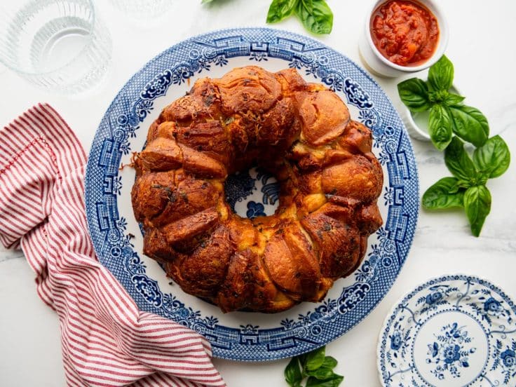 Horizontal overhead image of a blue and white platter with a pull apart garlic bread.